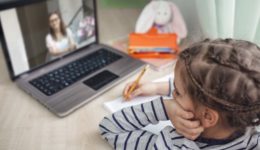 Pretty stylish schoolgirl studying math during her online lesson